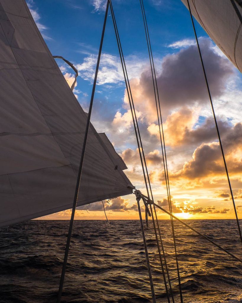 Voiles et coucher de soleil en mer, bateau-stop