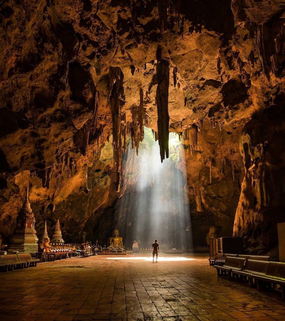 Temple dans une grotte traversée par un rayon de lumière, Asie du Sud-Est