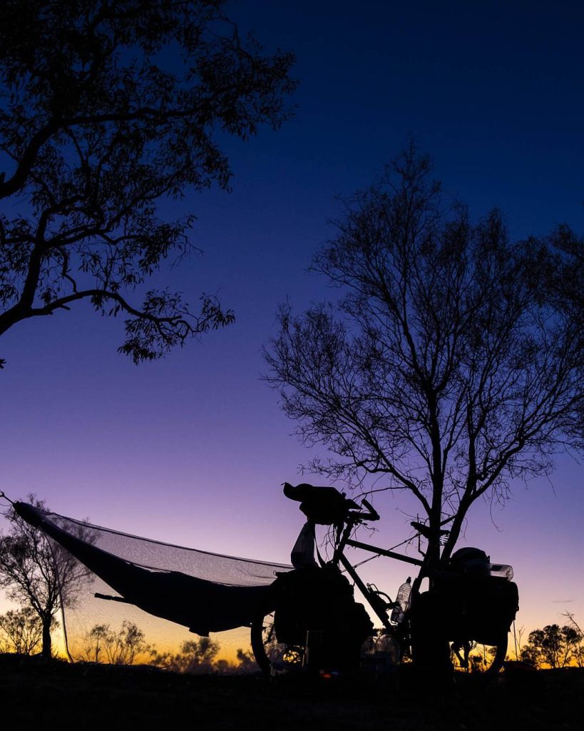 Hamac et vélo sous un arbre au crépuscule