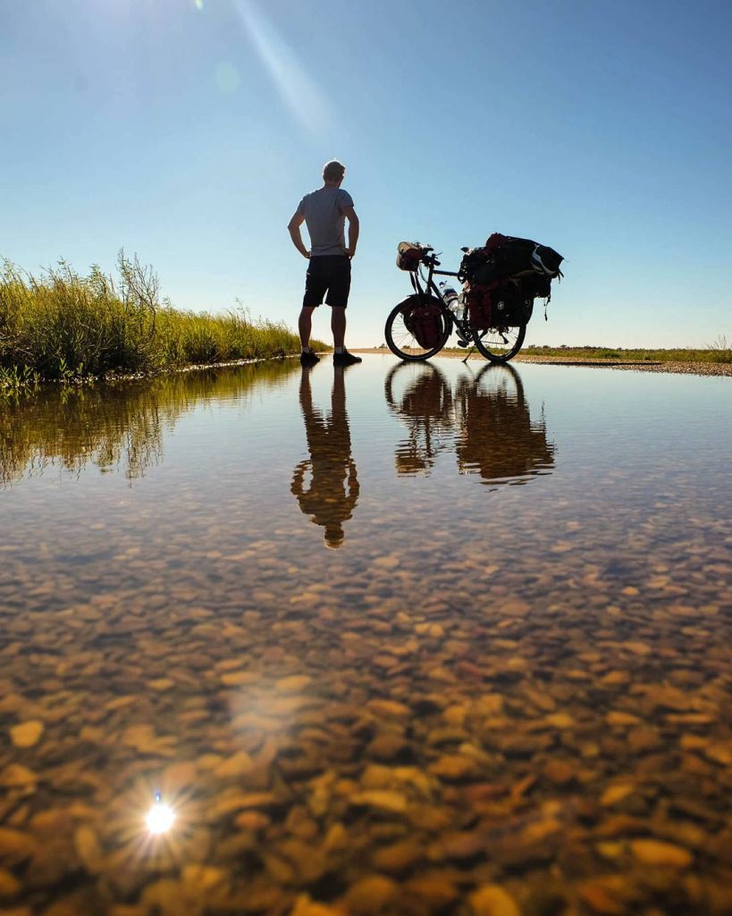 Reflet d'un cycliste et de son vélo dans l'eau